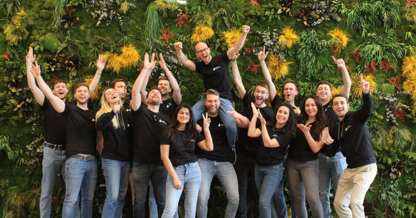 Mitarbeiter Teamfoto von specter automation im ConTech Startup vor grüner Wand.