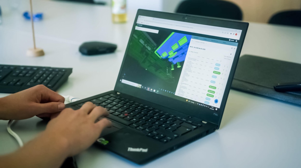 Auf dem Tisch steht ein Laptop, der die digitale Baudokumentation im Generalunternehmen zeigt.